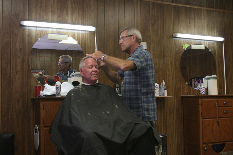 Barber Ray Clifton, cutting Tim Buckmaster's hair, is retiring after more than four decades of lowering men’s ears. At 5 p.m., on Friday, Sept. 27, Clifton and longtime coworker Ralph Holston, who is also retiring, will close the Center Barbershop’s doors for the last time. BY HENRY J. EVANS JR.